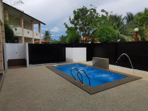 a swimming pool with a fountain in a yard at Adina Drive-In Motel Cenang - Managed By Shell Out Resort in Pantai Cenang