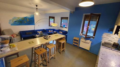 布加勒斯特的住宿－Popcorn Hostel，客厅配有桌子和蓝色的墙壁