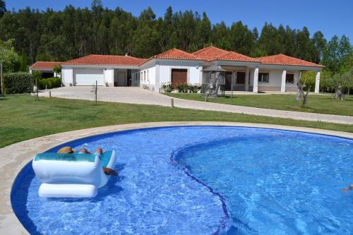 a swimming pool with a chair in front of a house at MountView in Alenquer