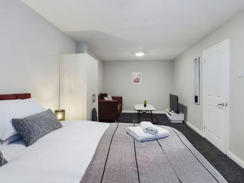 um quarto com uma grande cama branca e uma mesa em Luxury Accommodation with TVs in each Room em Macclesfield