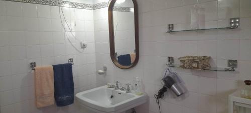 uma casa de banho branca com um lavatório e um espelho em Casa Amarela em Esmoriz