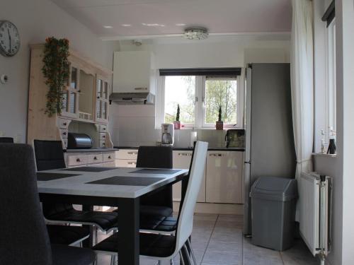 eine Küche mit einem Tisch und Stühlen im Zimmer in der Unterkunft Nice holiday home with garden, on a holiday park 200m from the beach in Wemeldinge