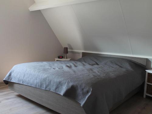 ein Schlafzimmer mit einem Bett und einer weißen Decke in der Unterkunft Nice holiday home with garden, on a holiday park 200m from the beach in Wemeldinge