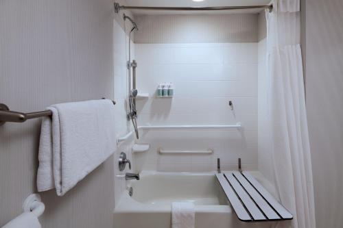 a bathroom with a bath tub and a toilet at Courtyard by Marriott Omaha Aksarben Village in Omaha