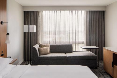 Houston Marriott South at Hobby Airport في هيوستن: غرفة في الفندق مع أريكة ونافذة