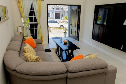 ein Wohnzimmer mit einem Sofa und einem Tisch in der Unterkunft Modern & Spacious 2-BDRM/ Gated/Near Ocho Rios in Boscobel