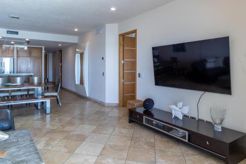 a living room with a large flat screen tv on a wall at Playa Blanca Condo - 9th Floor Ocean Views! in San Carlos