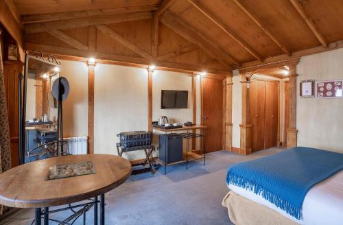 ein Schlafzimmer mit einem Bett und einem Tisch in einem Zimmer in der Unterkunft Hotel Los Ñires in Ushuaia