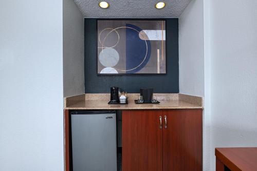 a small kitchen with a refrigerator and a counter at Courtyard by Marriott Dallas Arlington Entertainment District in Arlington