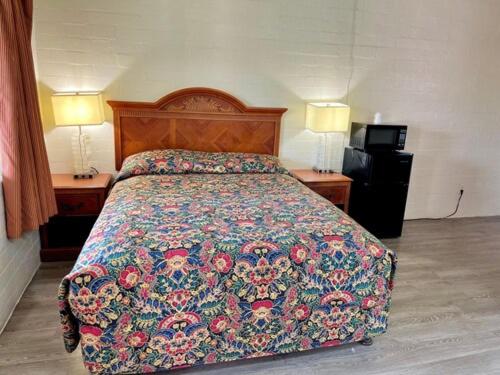 Bett in einem Hotelzimmer mit 2 Lampen an Tischen in der Unterkunft Border Motel in Calexico