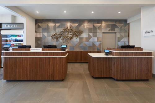 a lobby of a store with reception desks and a chandelier at Courtyard by Marriott Kitchener in Kitchener
