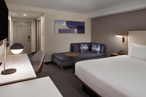 a hotel room with a bed and a couch at Courtyard by Marriott Kitchener in Kitchener