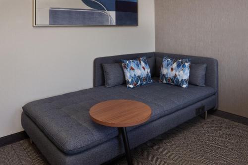 a living room with a blue couch and a wooden table at Courtyard by Marriott Kitchener in Kitchener