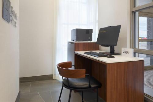 a computer sitting on a desk with a chair at Courtyard by Marriott Kitchener in Kitchener