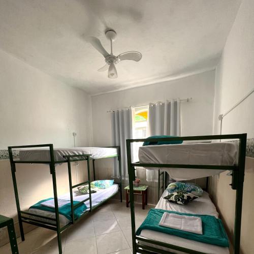 a room with two bunk beds and a ceiling fan at Casa Jardim Hostel BH - Santa Efigênia - Paraíso in Belo Horizonte