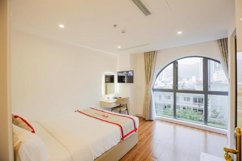 a bedroom with a bed and a large window at Kana Hotel Nha Trang in Nha Trang