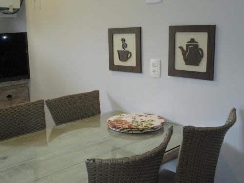ein Esszimmer mit einem Tisch mit Stühlen und einem Teller darauf in der Unterkunft Ilha flat hotel suíte Swaenen in Ilhabela
