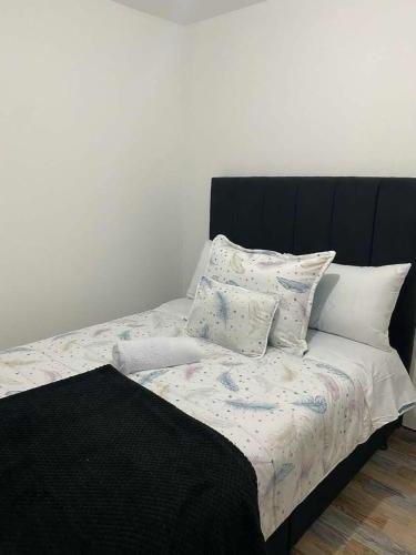 a bed with a black headboard and pillows on it at Hotel Amatista-Cerca al Aeropuerto in Bogotá