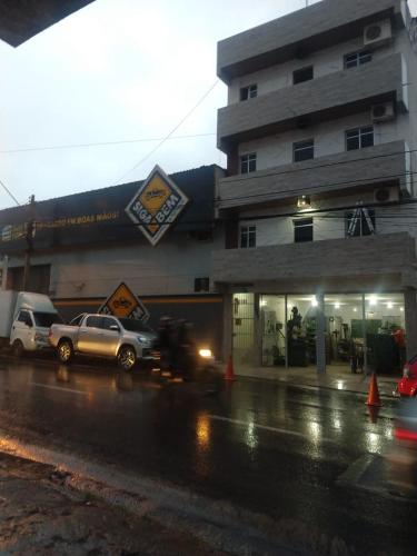 ein Gebäude mit Autos, die vor einem Geschäft geparkt sind in der Unterkunft kitnet encantadora no centro de Campina Grande -PB - APT 302 in Campina Grande