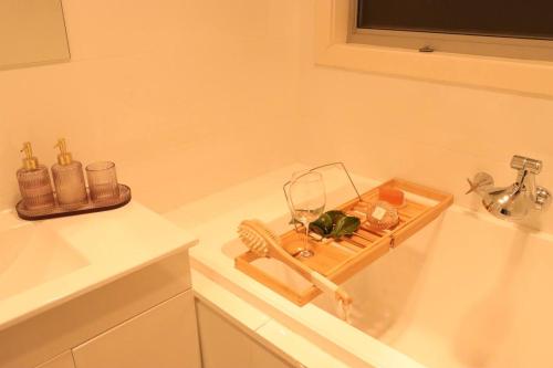 a bath tub with a tray with a glass of wine at Footscray home just 7km away to Melbourne CBD newly stylist setup in Melbourne