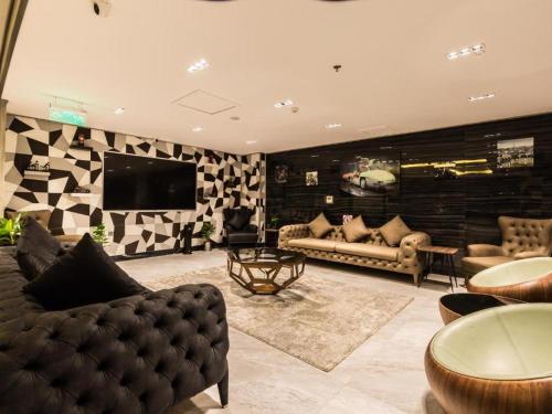 a living room with two couches and a television at Rasia Hotel Jeddah in Jeddah