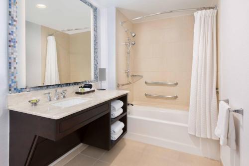 a bathroom with a sink and a shower and a tub at The Westshore Grand, A Tribute Portfolio Hotel, Tampa in Tampa