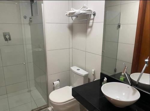 een badkamer met een toilet, een wastafel en een douche bij Residencial ILOA in Barra de São Miguel
