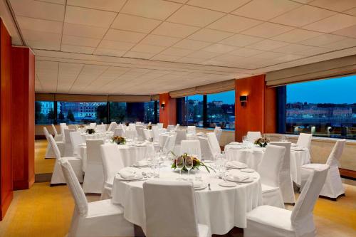 a banquet hall with white tables and chairs and windows at Sheraton Stockholm Hotel in Stockholm