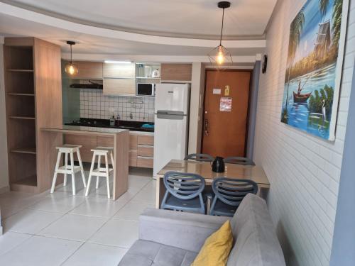 uma cozinha com um sofá, uma mesa e cadeiras em Excelente apartamento na praia de ponta verde em Maceió