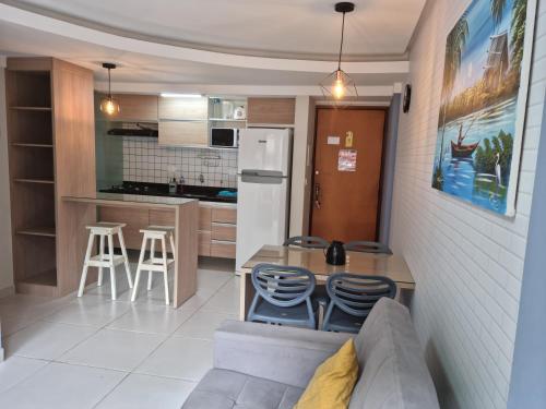 a kitchen with a couch and a table and chairs at Apartamento na praia de ponta verde com piscina e área de lazer in Maceió