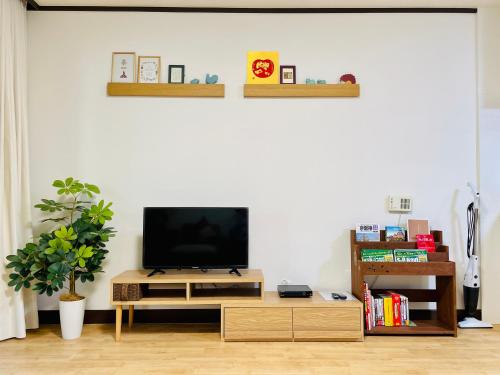 a living room with a tv on a white wall at 東寺楽屋 Toji Rakuya in Kyoto
