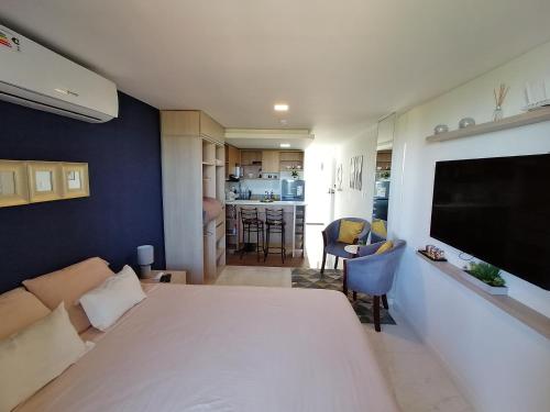 um quarto com uma grande cama branca e uma sala de estar em Hermoso Departamento completamente equipado em Colonia Mariano Roque Alonso