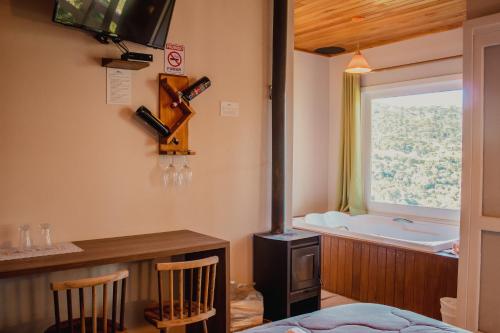 Habitación con bañera, mesa y sillas. en Pousada Lago da Colina, en Urubici