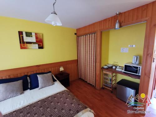 a hotel room with a bed and a microwave at Cabañas Bordenieve in Las Trancas