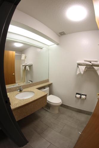 a bathroom with a toilet and a sink and a mirror at Americas Best Value Inn Prescott Valley in Prescott Valley