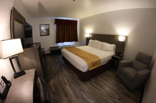 a hotel room with a bed and a chair at Americas Best Value Inn Prescott Valley in Prescott Valley