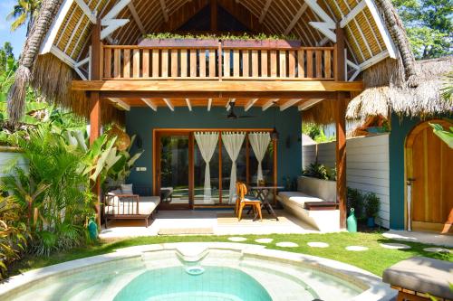 a villa with a swimming pool and a deck at Villa Tokay - Luxury Private Villas in Gili Air
