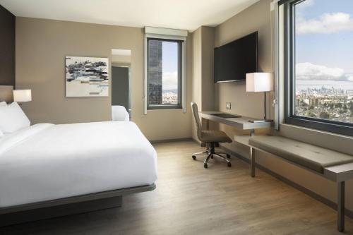 a hotel room with a bed and a desk with a computer at AC Hotel by Marriott Oakland Downtown in Oakland
