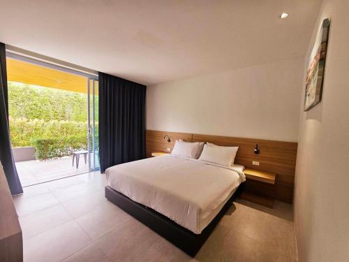 a bedroom with a large bed and a large window at AreNice Boutique Hotel in Surat Thani