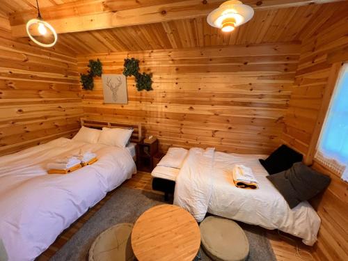 two beds in a room with wooden walls at Jyuuraku no mori - Vacation STAY 50432v in Awara