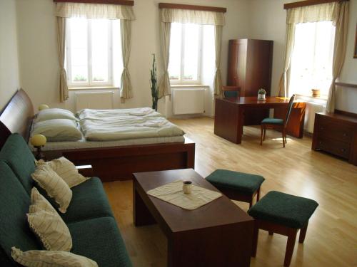 een woonkamer met een bank en een bed bij Městský Hotel Dorinka in Hostinné