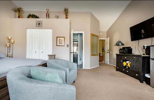 a bedroom with a bed and a chair and a tv at A Colorado Room With a View - King in Colorado Springs