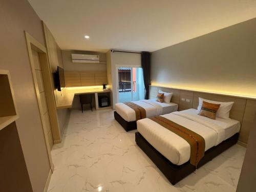 a hotel room with two beds and a desk at THE HUB SURATTHANl in Surat Thani