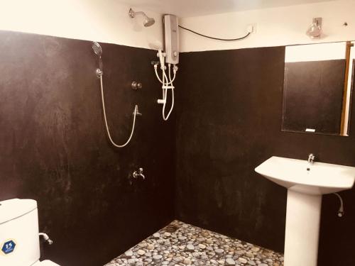 La salle de bains est pourvue d'une douche et d'un lavabo. dans l'établissement Wild Eagle Safari Resort, à Uda Walawe