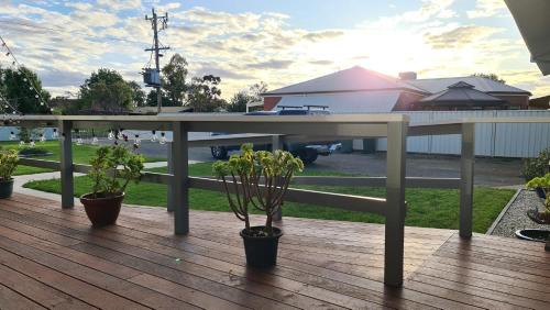 a picnic table on a deck with potted plants at ENGEDI in Tongala