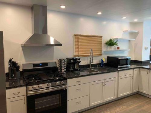 的住宿－Stylish & Cozy Home on the East Side of Pittsburgh，厨房配有白色橱柜和炉灶烤箱。
