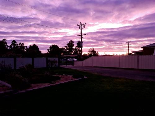 a sunset over a fence in a yard at ENGEDI in Tongala