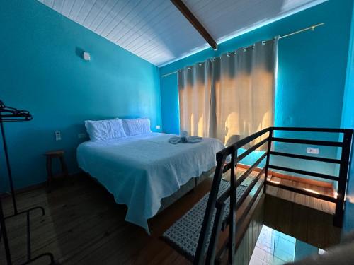 um quarto azul com uma cama e uma varanda em Cantinho Santiago em Alto Paraíso de Goiás