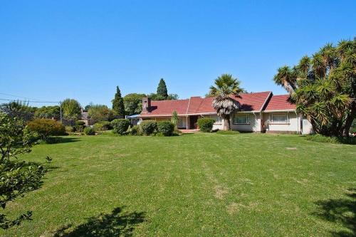 a house with a large yard with palm trees at Macum Haven Florida Park in Roodepoort