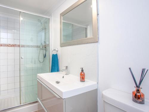 a white bathroom with a sink and a shower at Riverside Apartment in Bideford